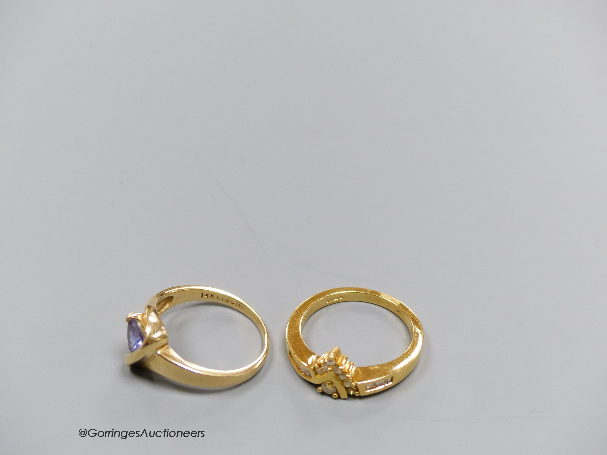 An 18ct gold and diamond dress ring, size N, gross 4.5g, and a 14k gold, diamond and tanzanite ring, size N, gross 3.7g.